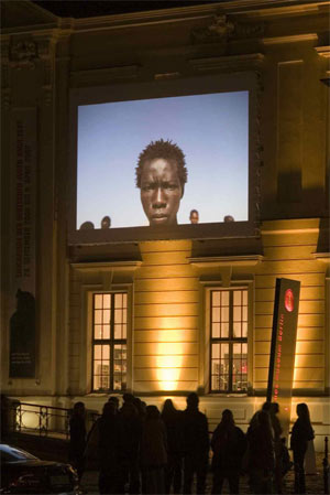 »Vor den Augen der Welt. Projektion von Fotografien aus Darfur« auf der Fassade des Museumsaltbaus - © Jüdisches Museum Berlin, Foto: Thomas Bruns