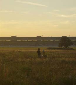The painter with an easel in front of the main building at Tempelhof Airport at sunset
