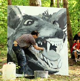 Man painting a wolf in a forest
