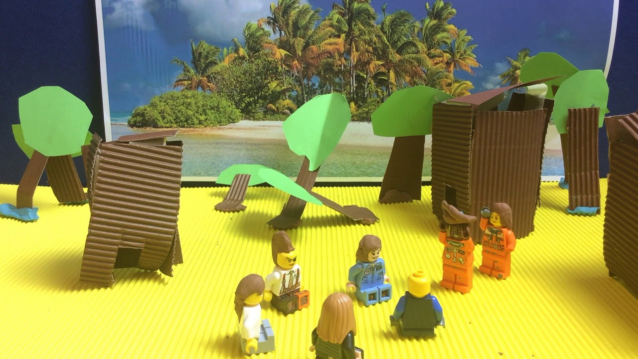 Legofiguren in einer aus Papier gebastelten tropischen Inselkulisse.