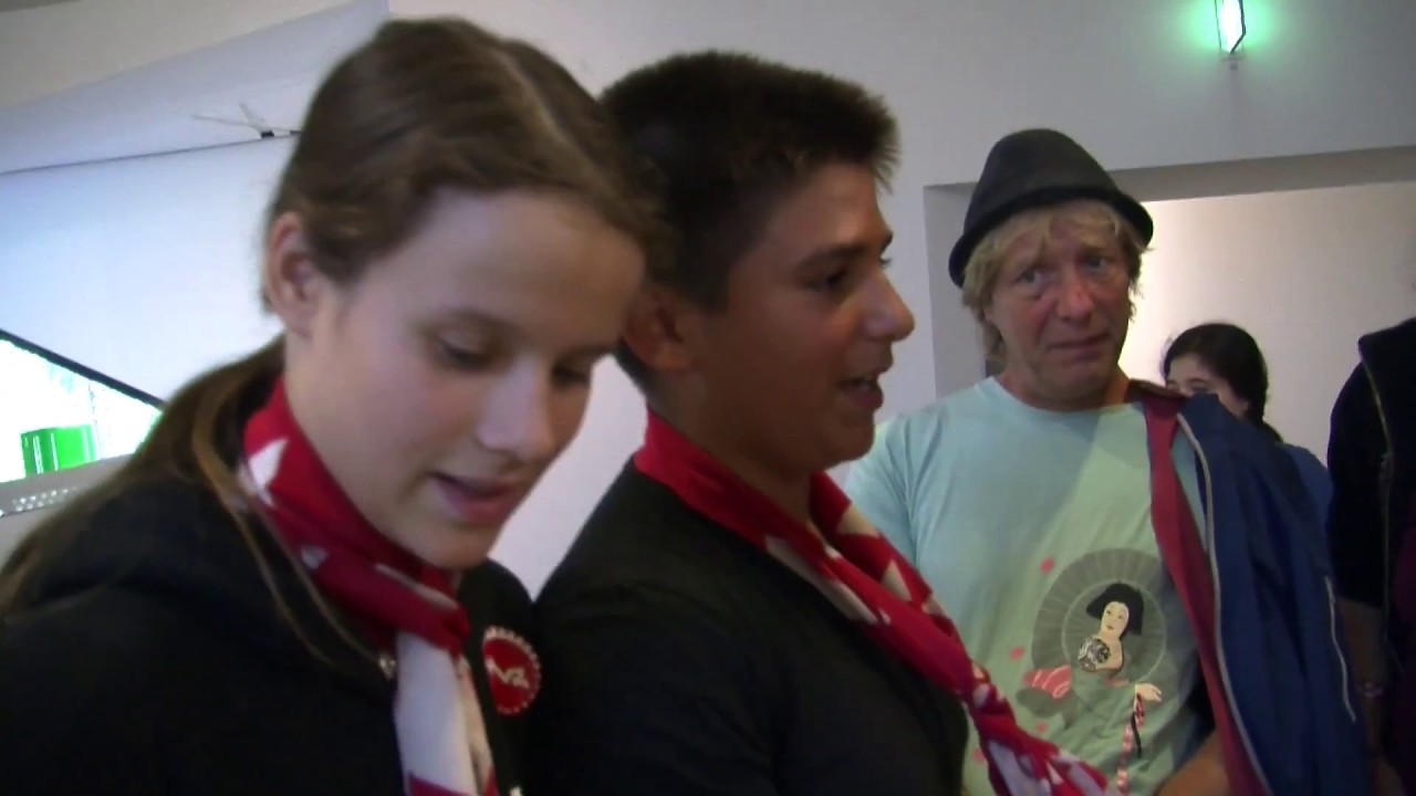 Two young people with red and white scarves give a guided tour of the museum.