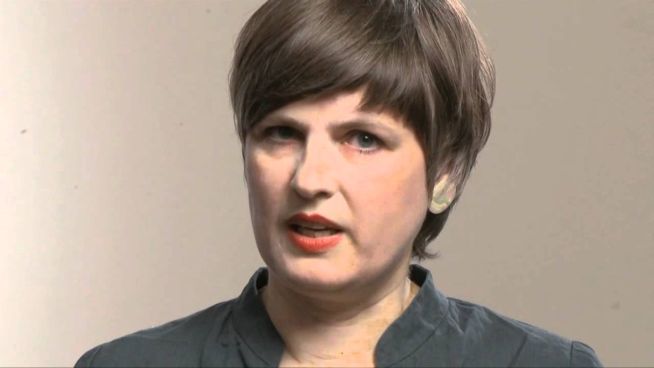 Woman with short black hair speaks into the camera.