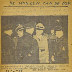 Handschriftlich verfasste Doppelseite mit eingeklebtem Foto aus Zeitung mit Männern in Uniform und Überschrift De Honden van de NSB.