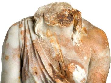 Female statue with traces of rust, missing the head