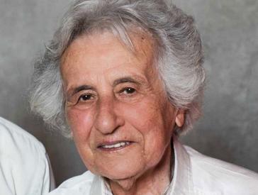 Portrait photo of an elderly woman looking friendly into the camera.