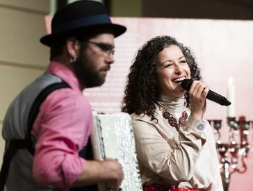 An accordion player and a singer make music on stage