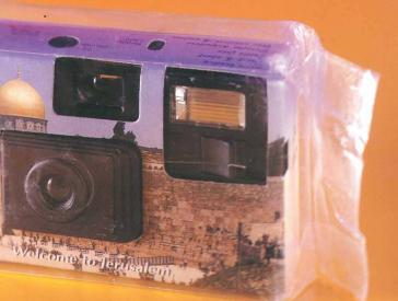 Einwegkamera in Plastikfolie, ihr Gehäuse ist mit einem Foto der Jerusalemer Altstadt bedruckt.