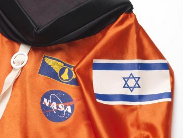 Ein oranger Anzug mit israelischer Flagge und NASA Aufnähern.