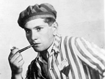 Young man in prisoner’s uniform, casually smoking a pipe.