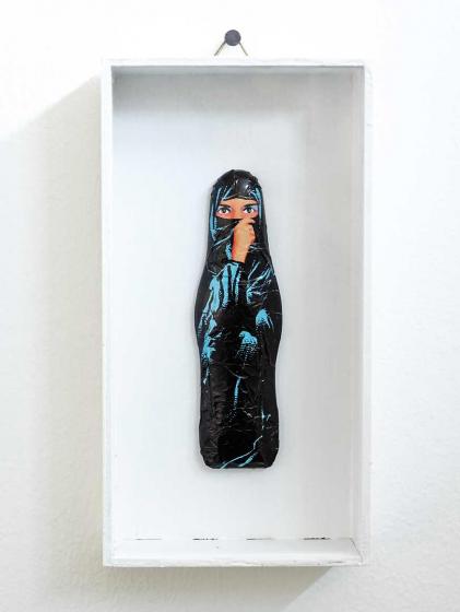 Chocolate in the shape of a woman in a full-body veil, in a white frame