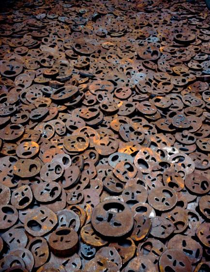 Meer von Gesichtern aus Eisenplatten mit aufgerissenen Mündern