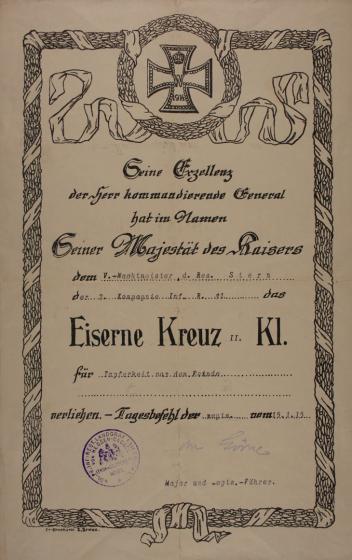 Urkunde, umrahmt mit Lorbeermotiv, oben zentral Darstellung eines Eisernen Kreuzes mit Jahreszahl 1914 und Krone