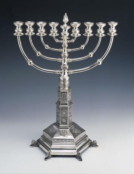 Richly decorated silver Hanukkah menorah, at the foot six lions