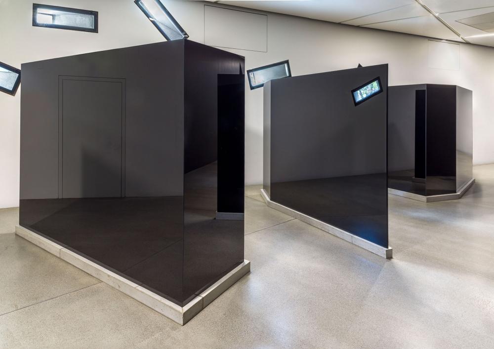 Three trapezoidal black-glass sculptures