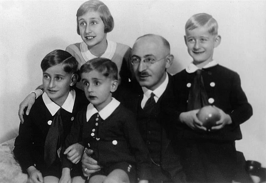Schwarz-Weiß-Foto, das einen Mann umringt von seiner Tochter und seinen drei Söhnen zeigt