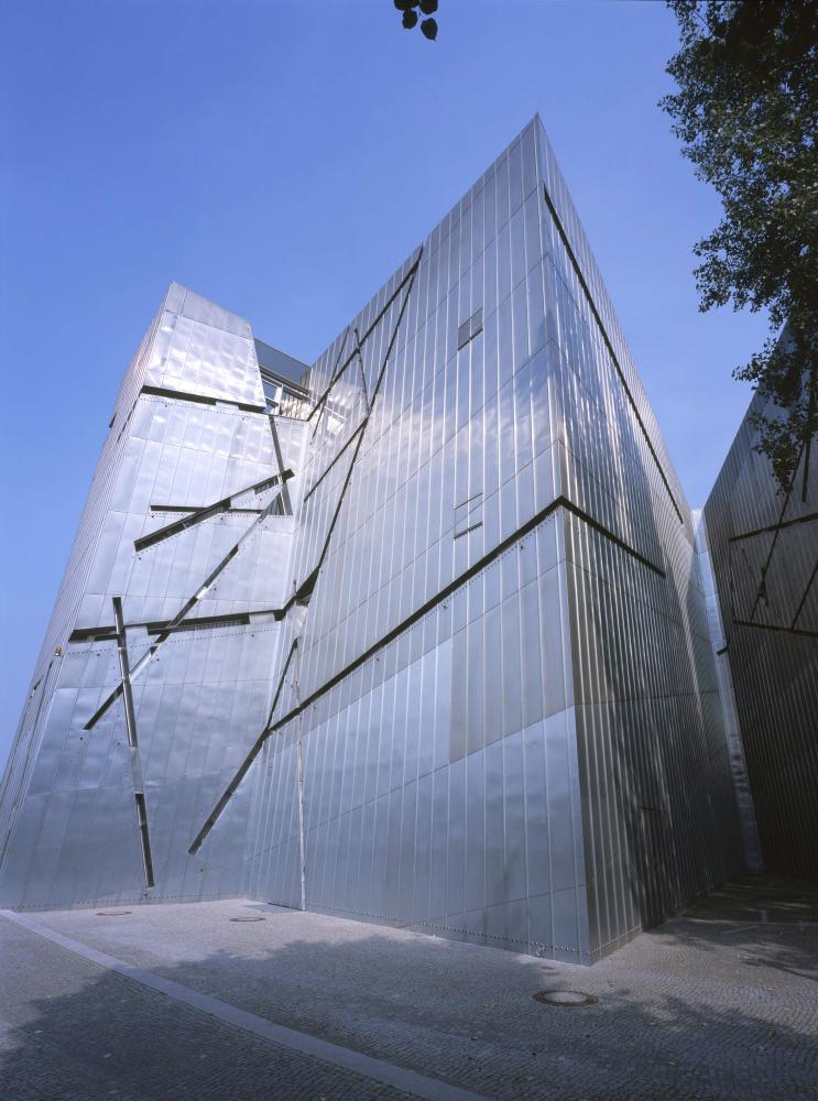 Teil der Fassade des Libeskind-Baus aus grauem Titanzink, mit sich kreuzenden und schräg verlaufenden Fenstern.