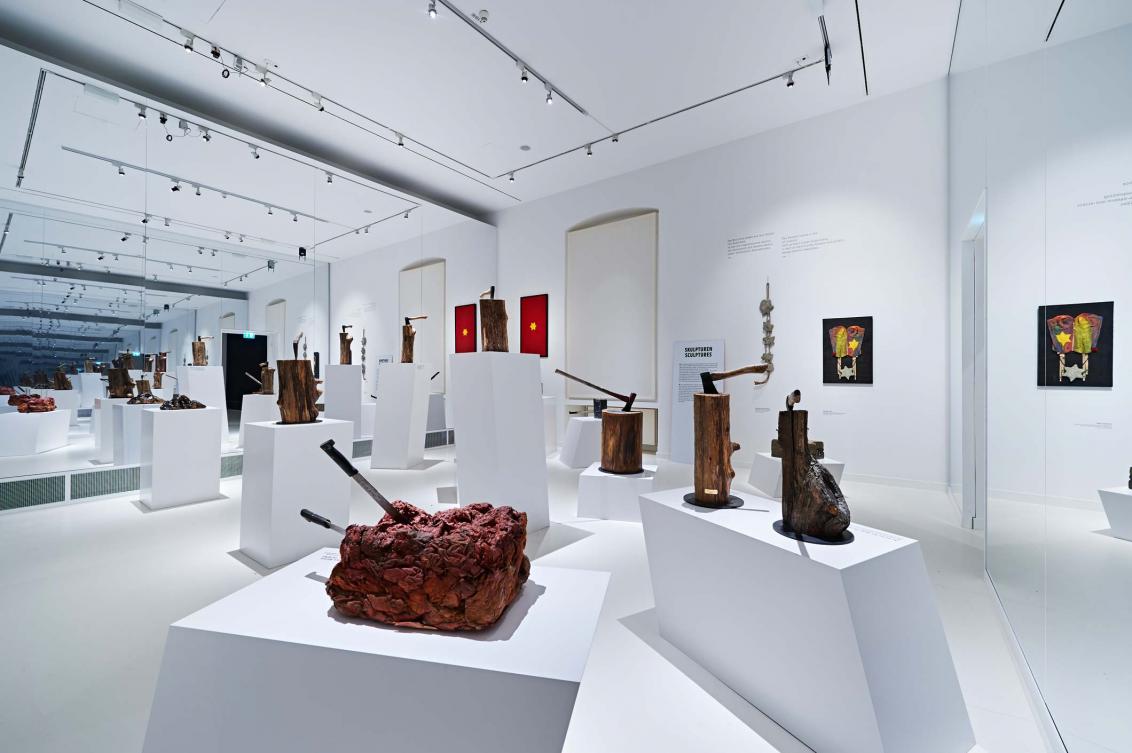 Exhibit space of sculptures of various material like wood or stone with axes and knifes stuck in them
