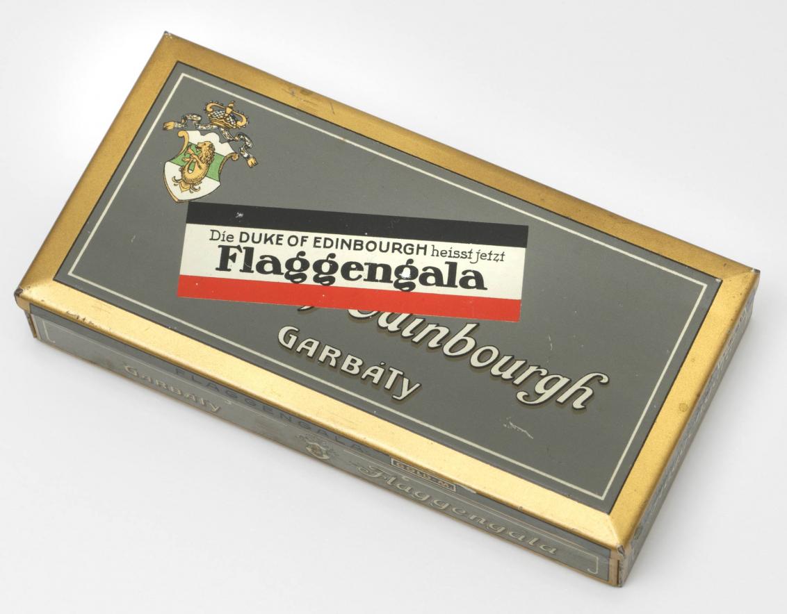Zigarettendose mit Garbáty-Wappen, beschriftet mit „Duke of Edinbourgh“ und „Die Duke of Edinbourgh heisst jetzt Flaggengala“