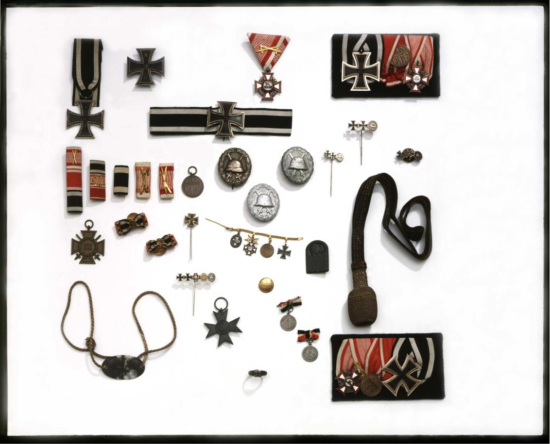 Assortment of objects including badges and pin, many of which have the Iron Cross