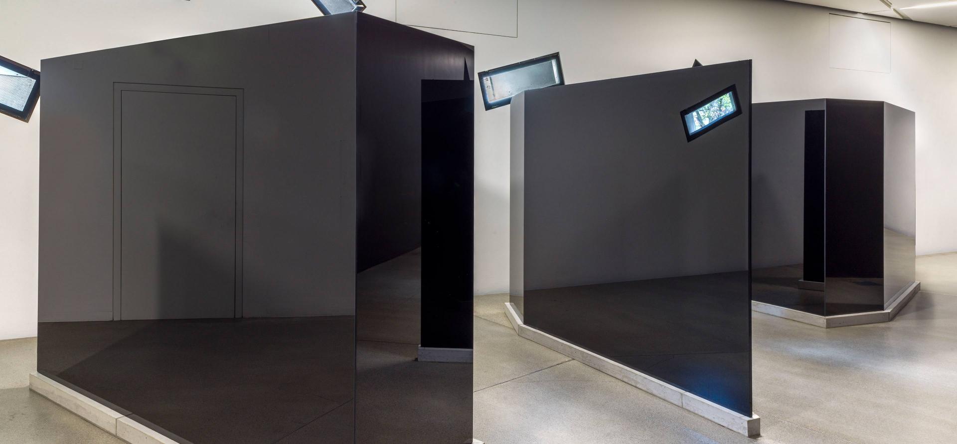 Drei schwarze, trapezförmige Glasskulpturen