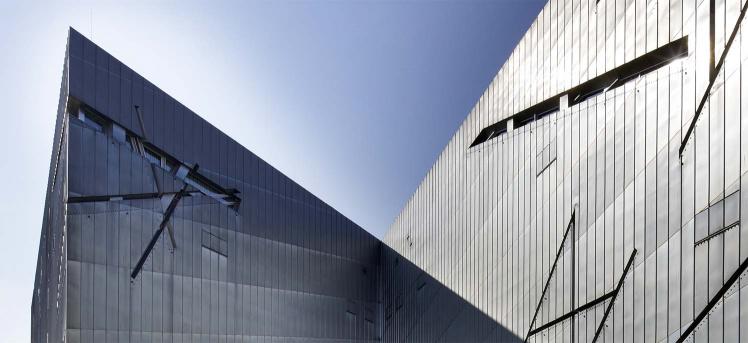 View of the zinc facade of the Libeskind Building against a blue sky (detail) 