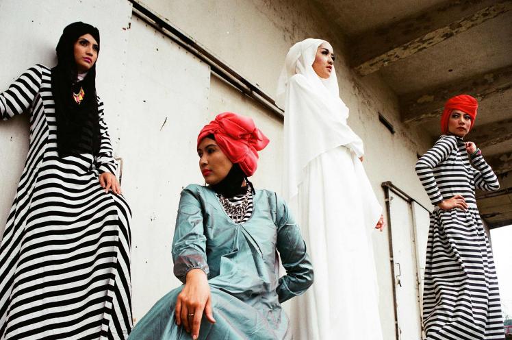 Vier Frauen in langen Kleidern und Hijabs