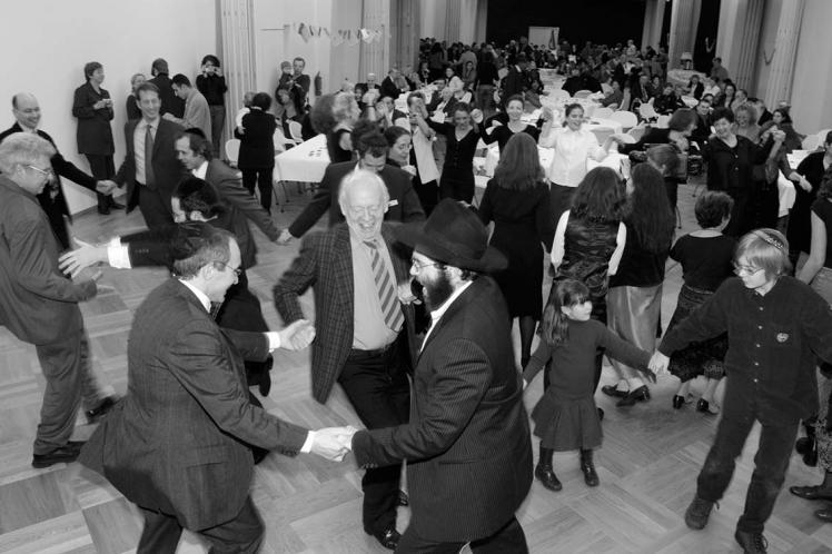 Black and white photograph: Dancing people in a hall.