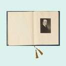 Open book, on the right a portrait photograph of a man in a dark suit and tie.