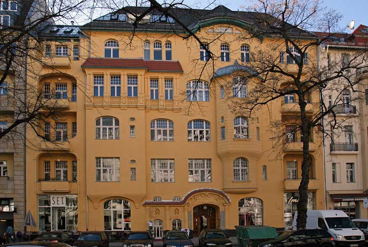 Yellow building faade with cars and trees