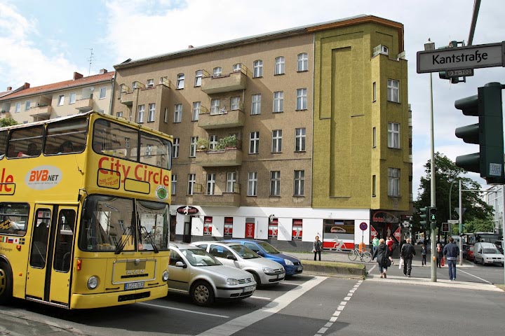 Straßenkreuzung mit Autos und Bus, Gebäude im Hintergrund