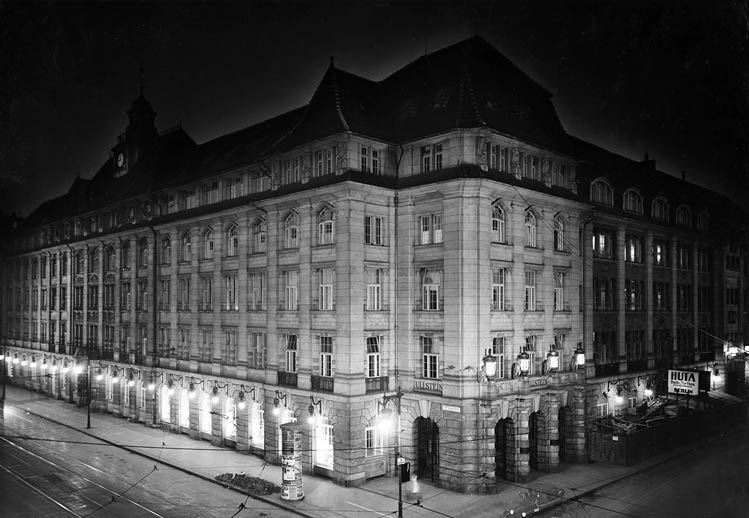 Black-and-white photo of an illuminated corner building.