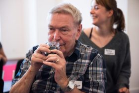 A man sniffs at a glass.