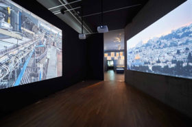 Exhibition room with two films playing on two large screens