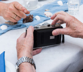 Hände hantieren mit einem alten Fotoapparat