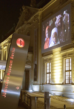 »Vor den Augen der Welt. Projektion von Fotografien aus Darfur« auf der Fassade des Museumsaltbaus - © Jüdisches Museum Berlin, Foto: Thomas Bruns