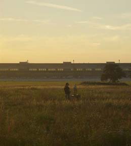 Maler mit Staffelei vor dem Flughafengebäude Tempelhof bei Sonnenuntergang