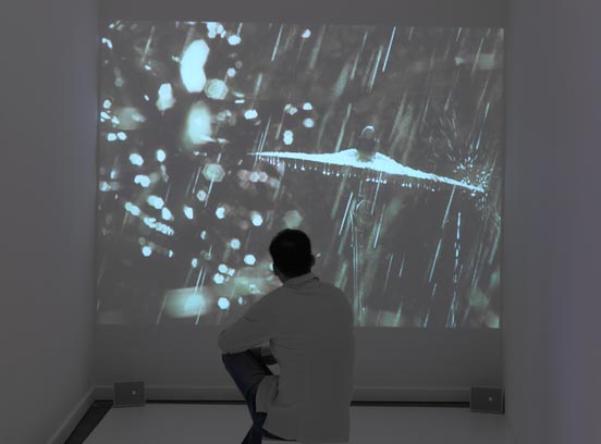 a visitor is sitting in front of a video projection 