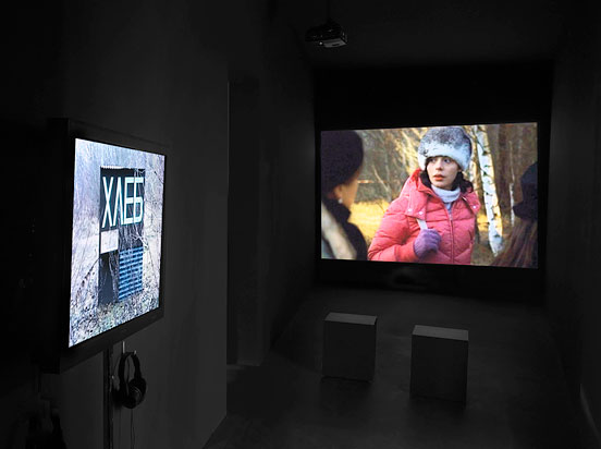 dark room with two monitors, on which films are playing