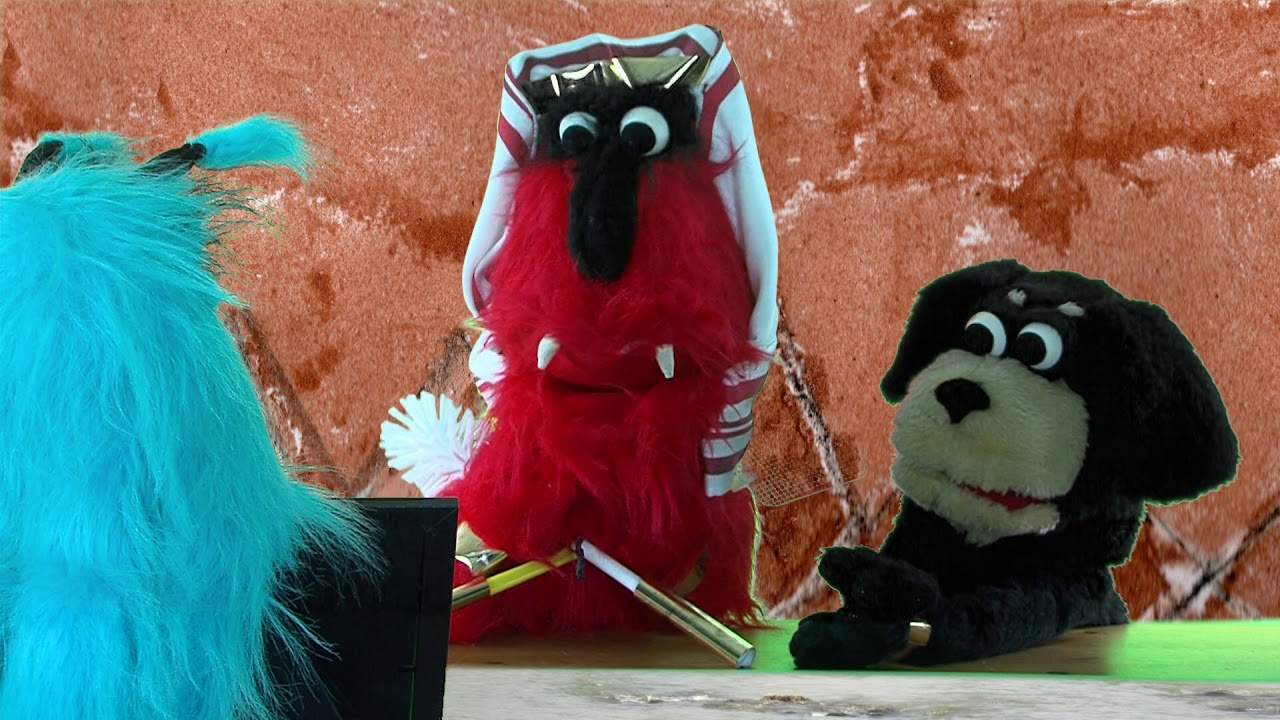 Three hand puppets interact with each other.