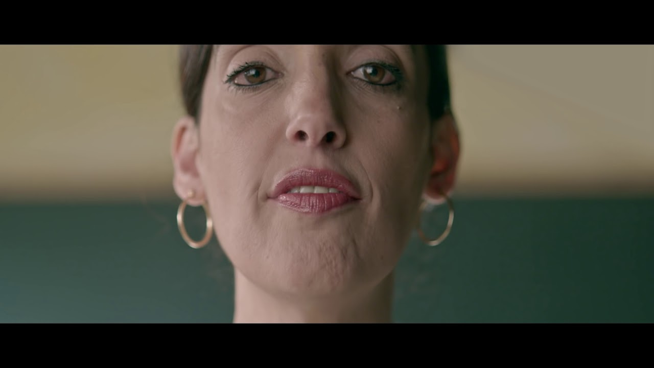 Close-up of a woman's face. She looks slightly into the camera from above.