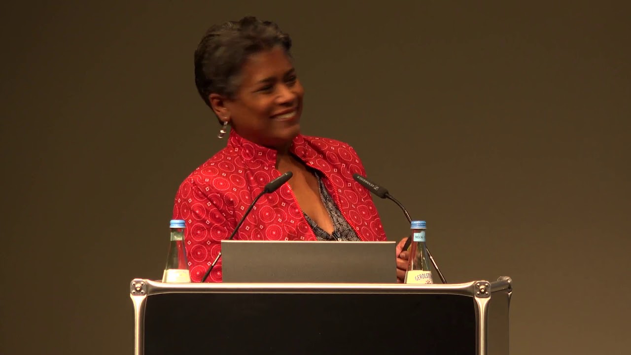 Woman stands at the lectern and laughs.