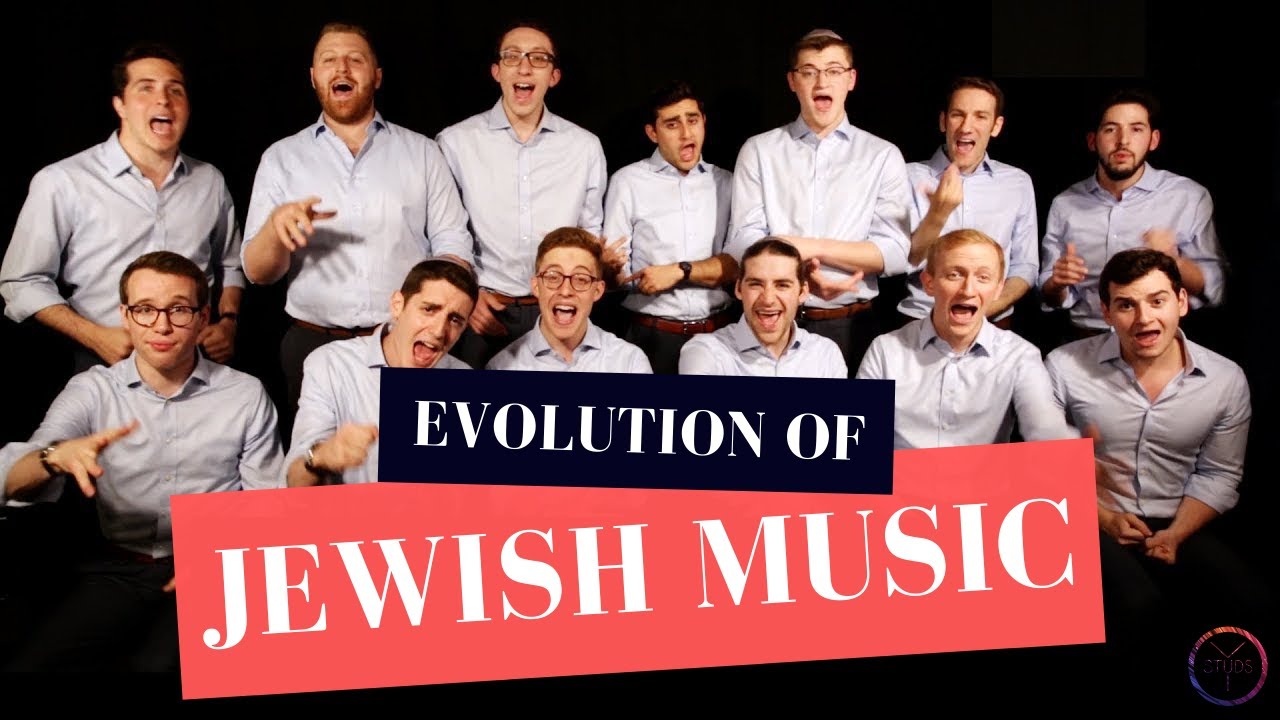Thirteen people stand in front of a black background and sing into the camera. The words "Evolution of Jewish Music" can be read in the front.