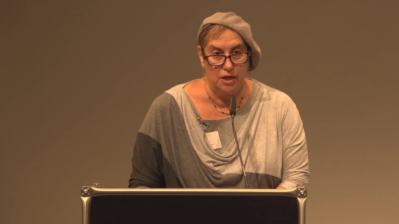 Woman at lectern gives a lecture.