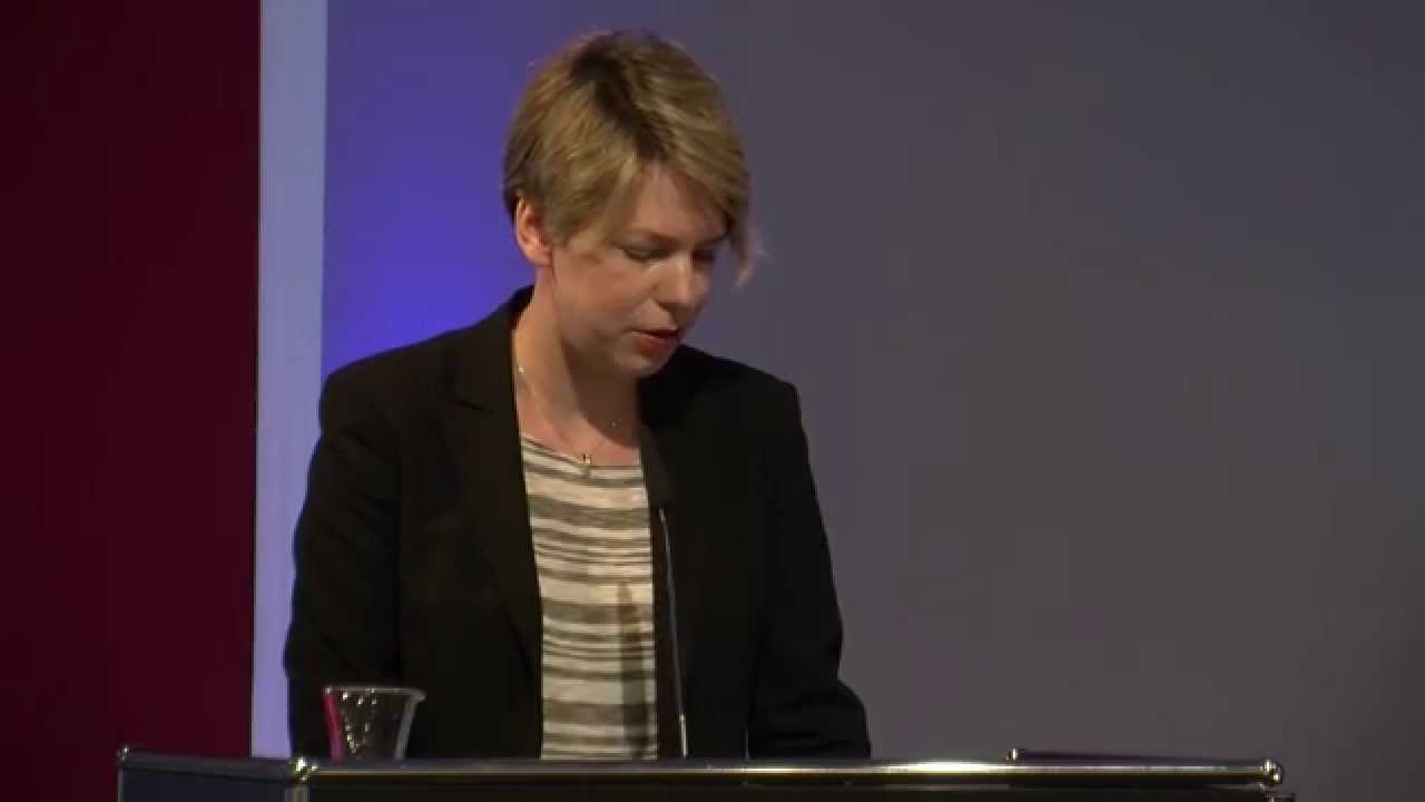 Woman stands at the lectern and speaks.