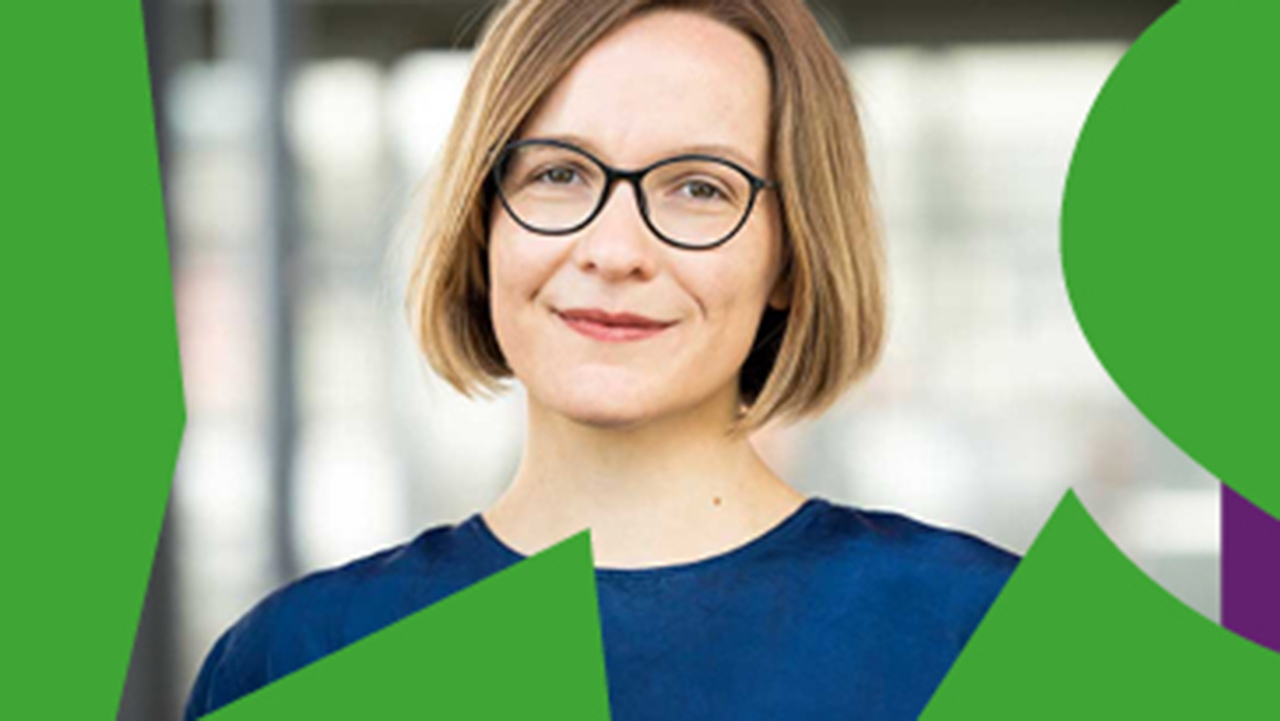 Photo of a woman with short blond hair, black glasses and blue sweater smiling at the camera, around it purple-green frame.