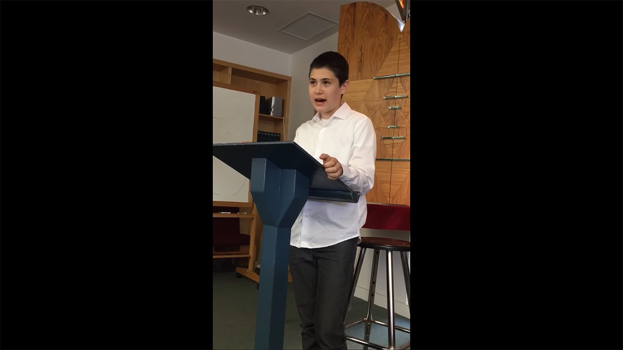 Young person stands at the lectern and speaks.