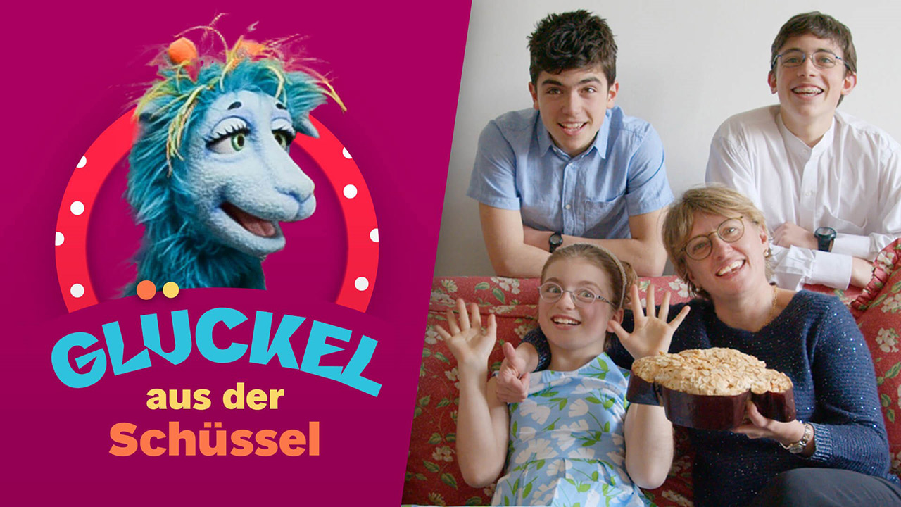 Eine Frau hält einen Kuchen in Form einer Taube, um sie herum drei Kinder, alle lachen in die Kamera; neben dem Foto das Logo der Koch-Show Glückel in der Schüssel