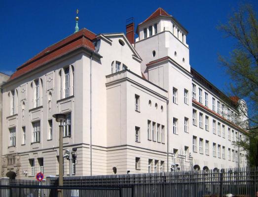 Large building with many windows, surrounded by a fence