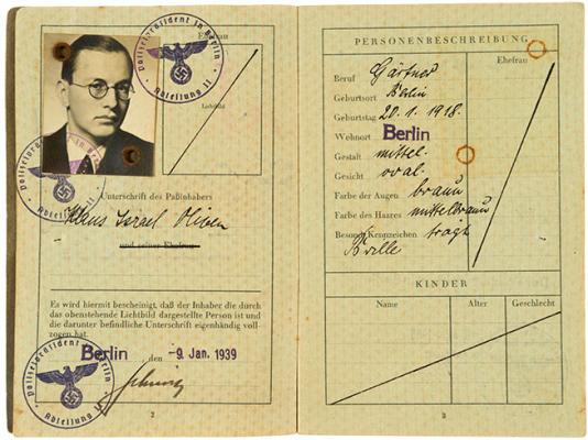 Eine Doppelseite aus einem alten Reisepass des Deutschen Reichs. Es sind ein Passfoto von einem jungem Mann mit runder Brille zu sehen und drei Stempel mit den Reichsadler.