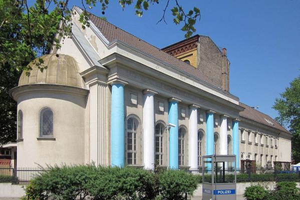 An elongated building with blue and white columns